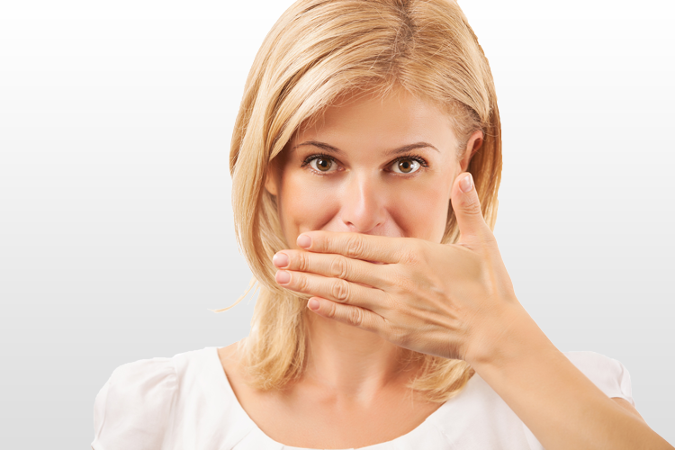 Woman covering mouth with hand, expressing surprise or concern about dental health