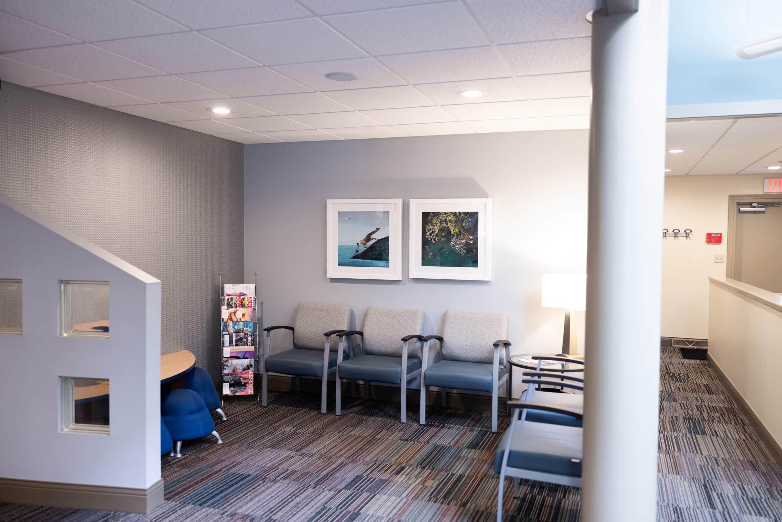 Modern dental waiting room with seating, framed artwork, and professional décor.