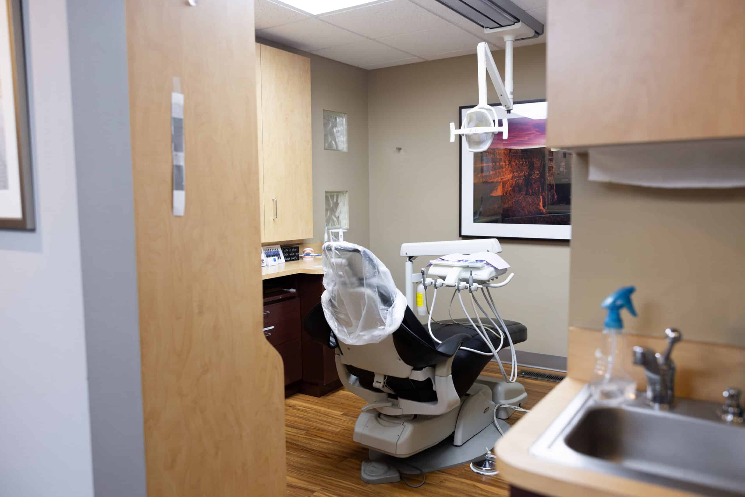 Modern dental operatory with chair, overhead light, and equipment in clinical treatment room.